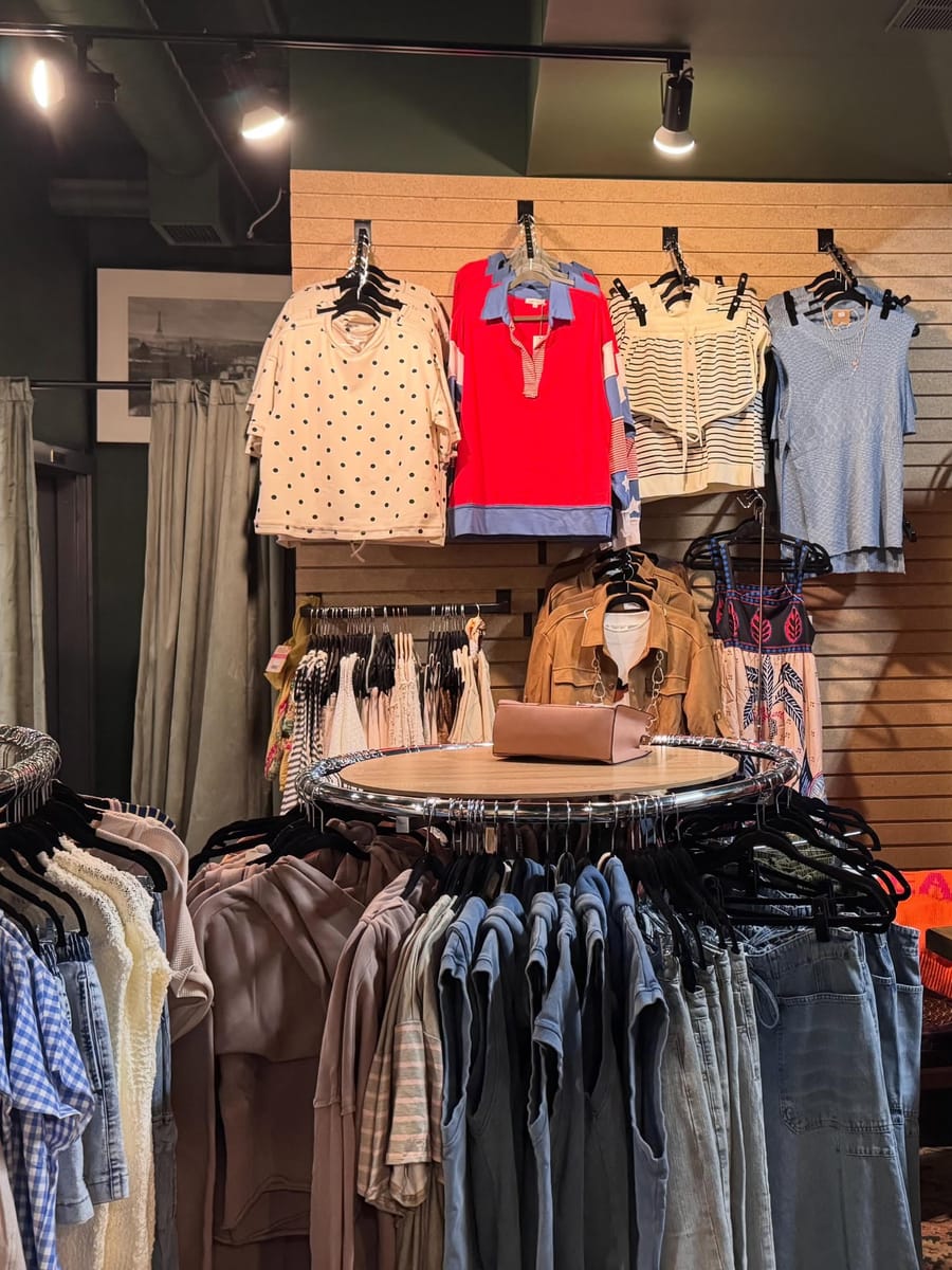 Inside the Dark Horse boutique — racks of curated apparel against deep green walls