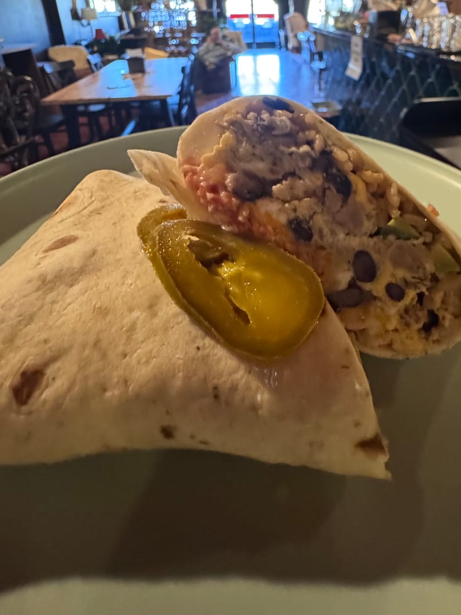 A scratch-made breakfast burrito on the bar at Dark Horse Brew, with the café dining room behind it