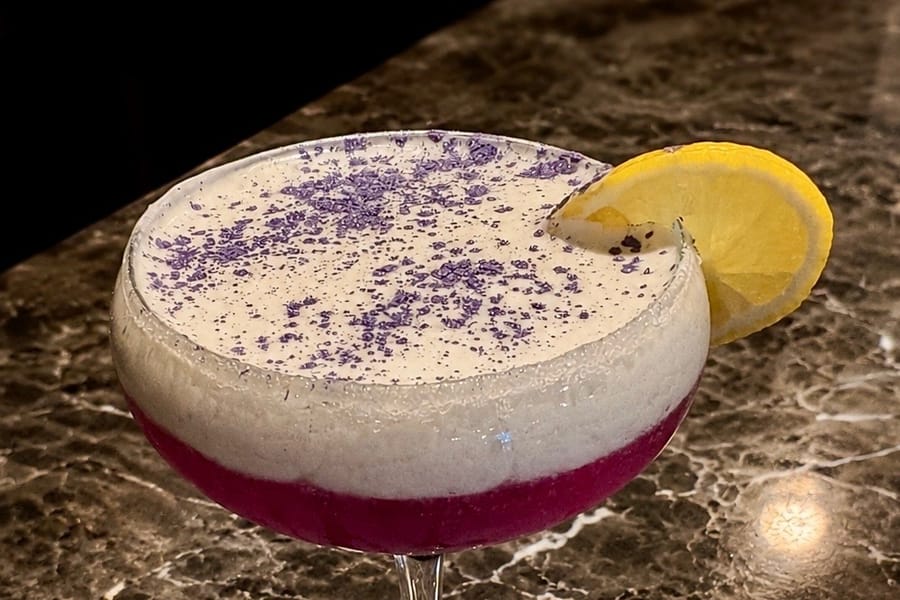 The Funkberry Fizz — a violet gin sparkler dusted with blueberry, garnished with a lemon wheel